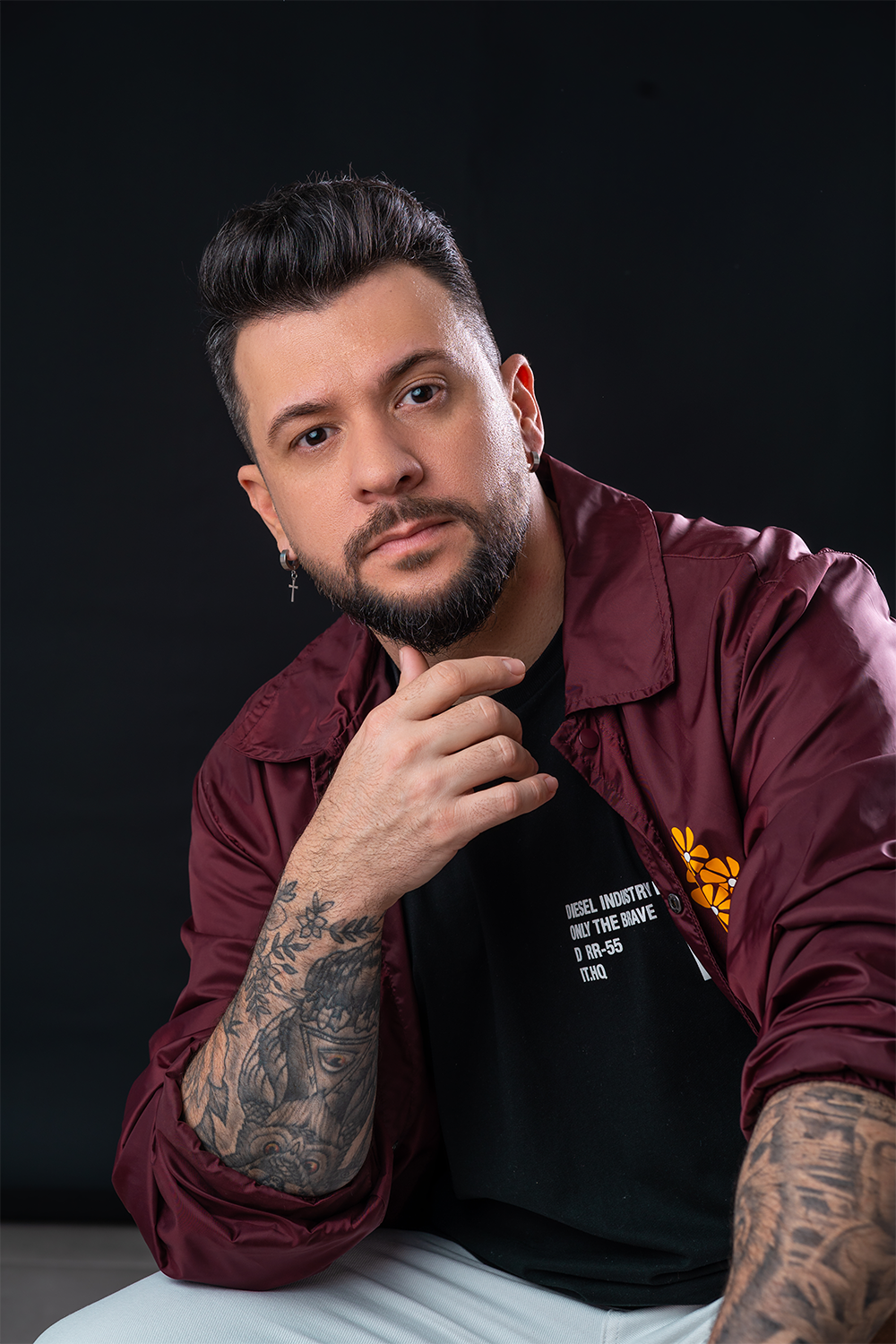 Retrato profissional de John Blanc em estúdio, com paletó bordô